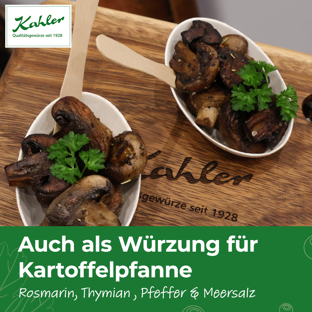 Zwei kleine weiße Schalen mit gebratenen Champignons und Petersilie auf einem Holzbrett mit dem Schriftzug "Kahler Qualitätsgewürze seit 1928"