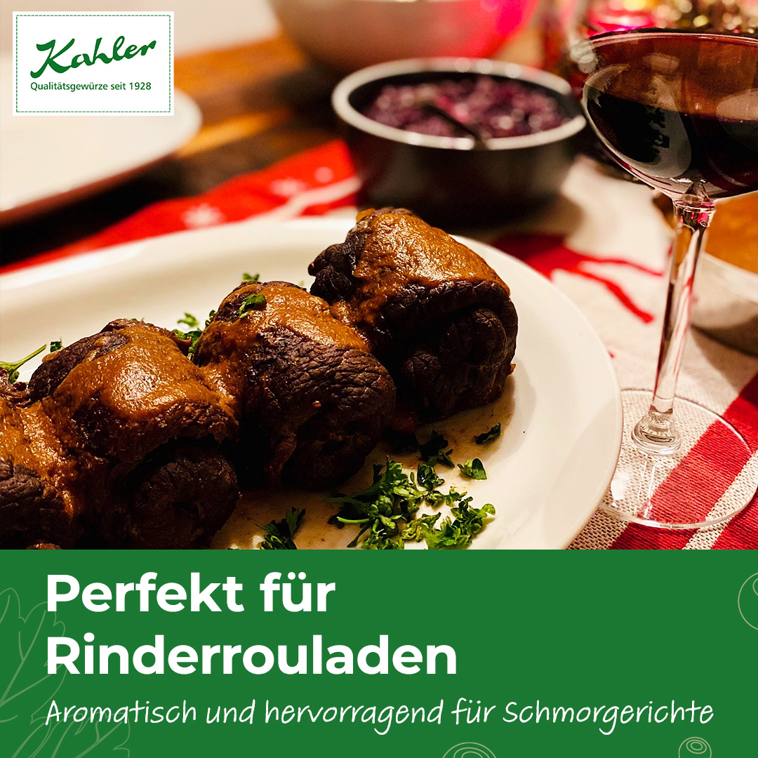 Drei gefüllte Rinderrouladen auf weißem Teller mit gehackter Petersilie daneben, im Hintergrund Glas Rotwein und Schüssel mit roter Sauce, oben das Logo Kahler
