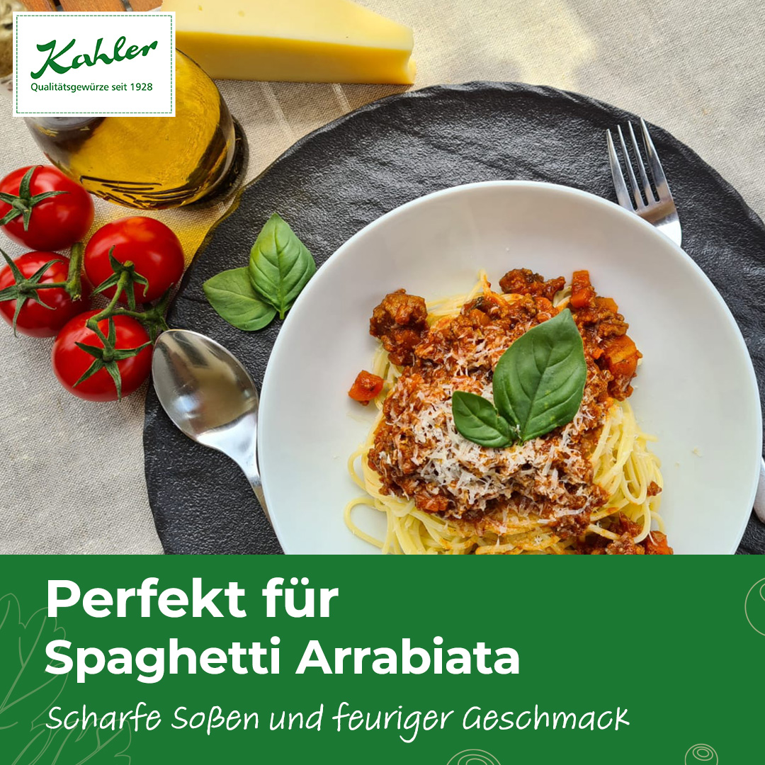 Teller mit Spaghetti Arrabiata, garniert mit Basilikumblättern, daneben Tomaten am Stiel, ein Stück Käse, eine Gabel und ein Löffel auf einem schwarzen runden Untersetzer und Kahler Logo am linken Rand