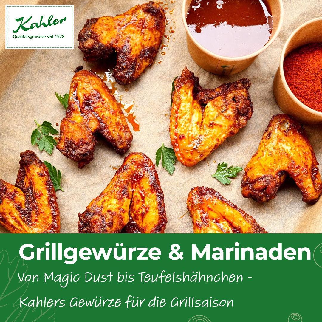 Mehrere gegrillte Hähnchenflügel auf Backpapier mit frischer Petersilie daneben und zwei Schalen mit Gewürzen und Sauce und Kahler Logo