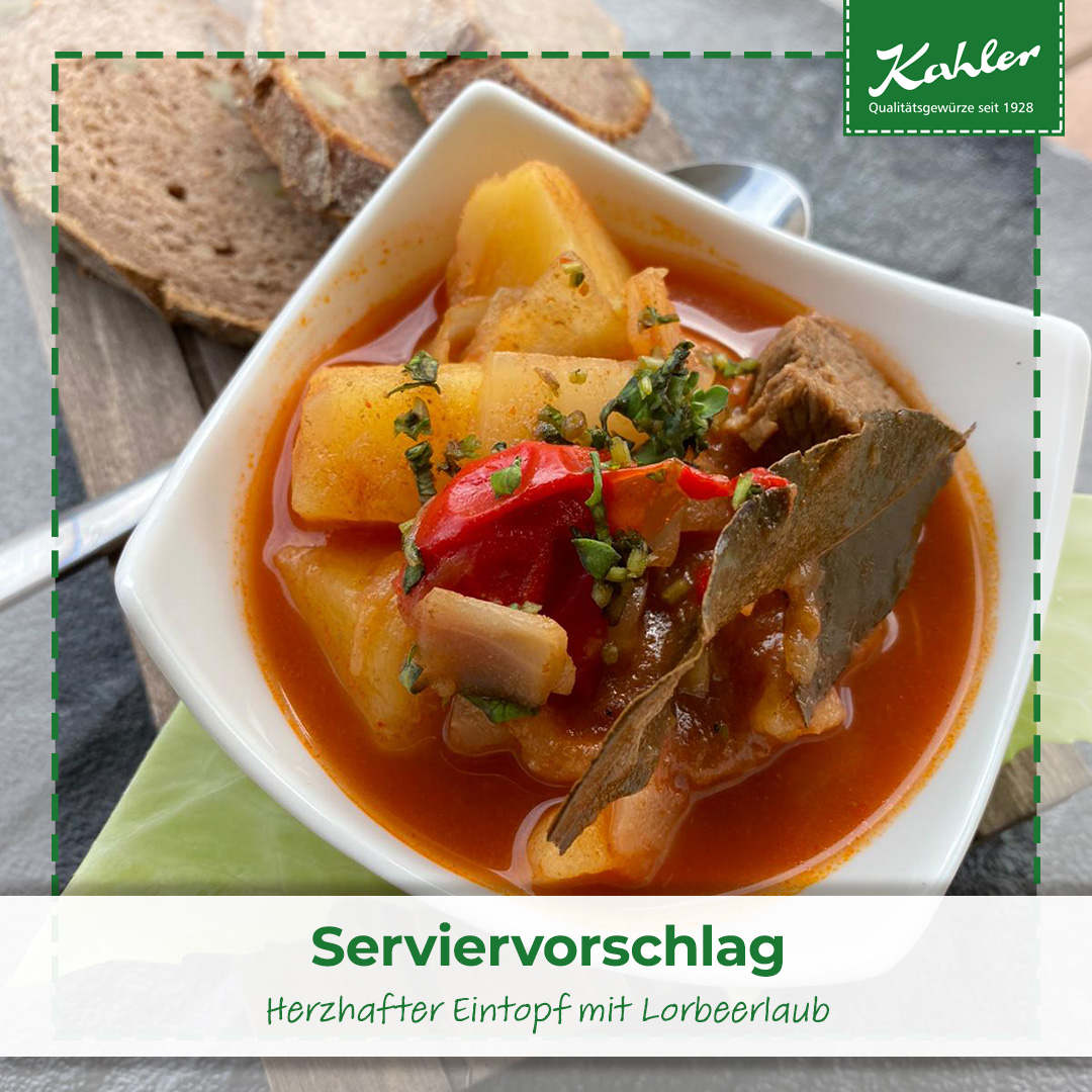 Herzhafter Eintopf mit Kartoffelstücken, roter Paprika, Lorbeerblatt und Kräutern in weißer Schale mit Brotscheiben im Hintergrund und Kahler Logo
