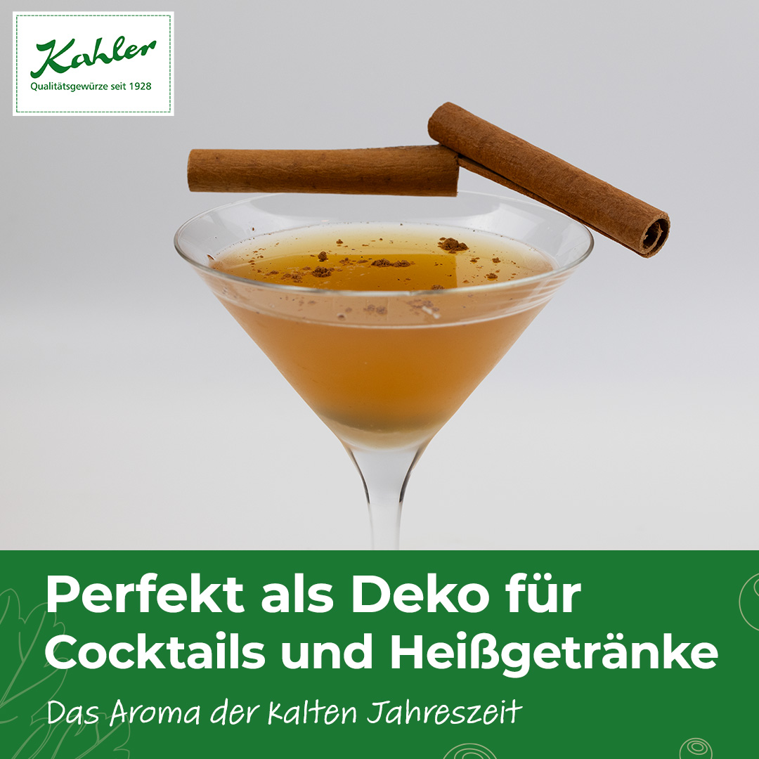 Cocktailglas mit braunem Getränk, garniert mit zwei Zimtstangen und Zimtpulver, darüber grüner Text auf weißem Hintergrund mit dem Schriftzug 'Perfekt als Deko für Cocktails und Heißgetränke Das Aroma der kalten Jahreszeit' und dem Logo 'Kahler Qualitätsg